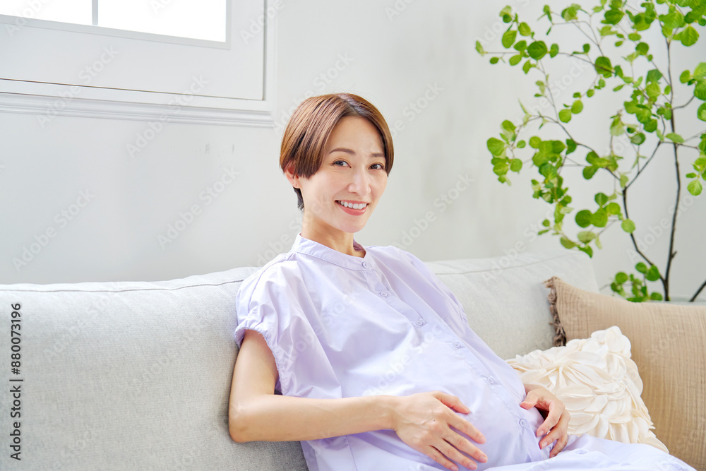 リビングで笑顔の高齢妊娠をした妊婦　カメラ目線　コピースペース