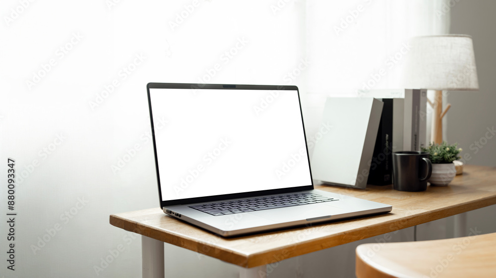 Open laptop with blank screen on a wooden desk in a kitchen room home office. Open laptop with blank screen on a wooden desk in a kitchen room home office.