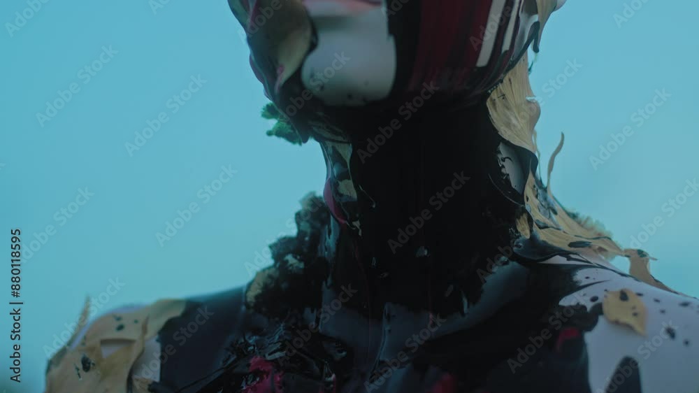 Red and black liquid drips down a mannequin standing in a field at dusk, close-up shot Red and black liquid drips down a mannequin standing in a field at dusk, close-up shot