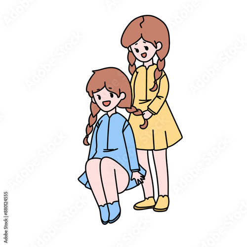 Two girls are sitting on the ground, one of them is wearing a blue dress