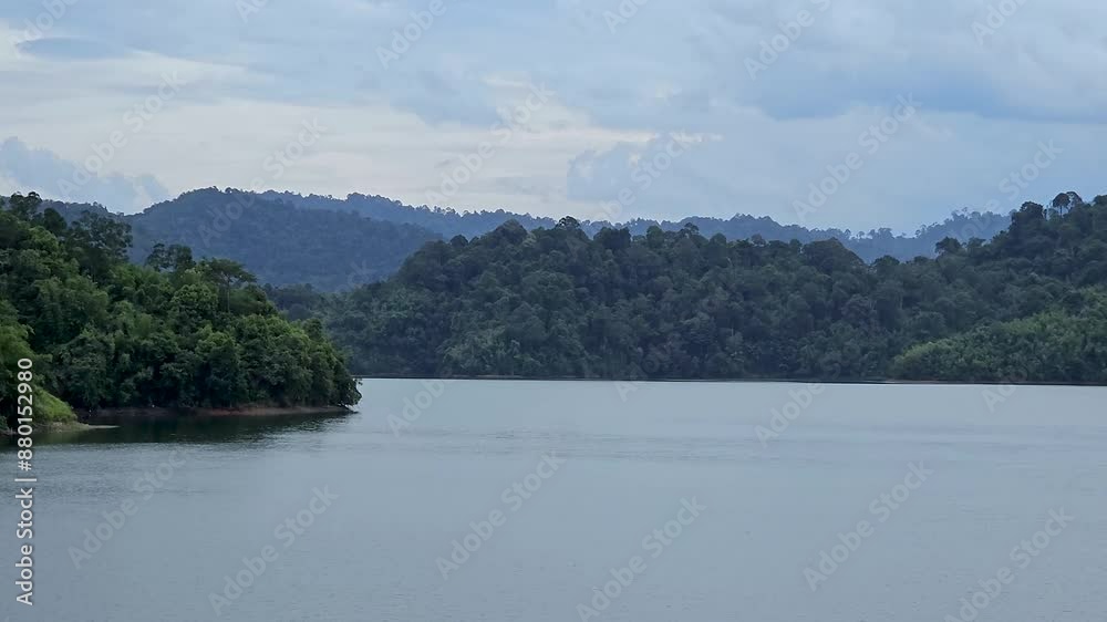 Beautiful lake and green mountain natural scenery in Kuala Kubu Bharu, Selangor, Malaysia. A large river bank with island trees and clouds. Pan shot Beautiful lake and green mountain natural scenery in Kuala Kubu Bharu, Selangor, Malaysia. A large river bank with island trees and clouds. Pan shot