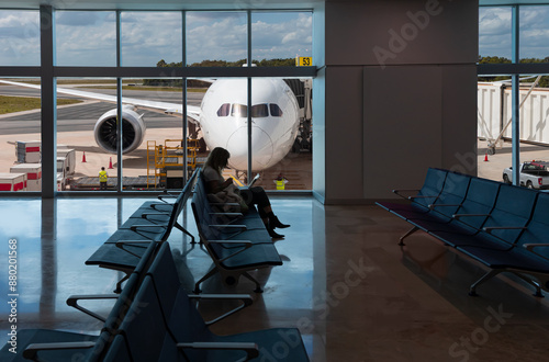 Silhouette of young woman working on laptop and waiting for flight in the Airport - Cancún International Airport  - Cancun, Mexico