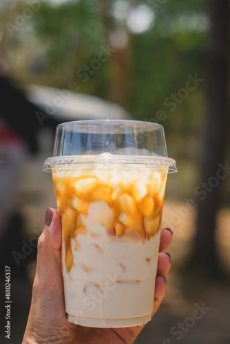 Hand Holding a Plastic Cup with a Refreshing Drink