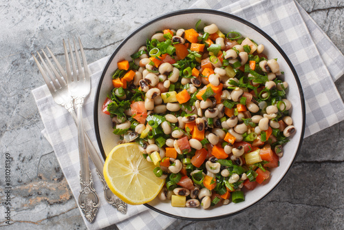 Salad of Mavromatika of Feneos made with black-eyed peas and vegetables closeup on the plate on the table. Horizontal top view from above photo