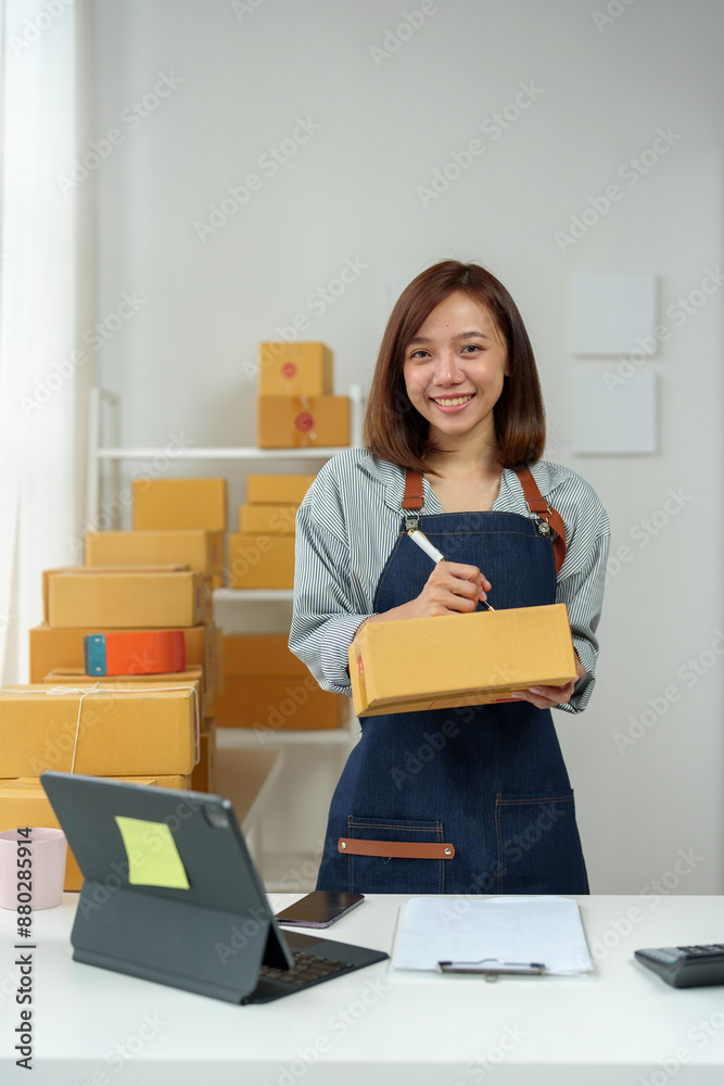 SME entrepreneurs, small businesses Online sales concept, happy Asian female business owner working on laptop computer and parcel boxes. Delivery of SME parcel boxes to customers Confirm order. SME entrepreneurs, small businesses Online sales concept, happy Asian female business owner working on laptop computer and parcel boxes. Delivery of SME parcel boxes to customers Confirm order.