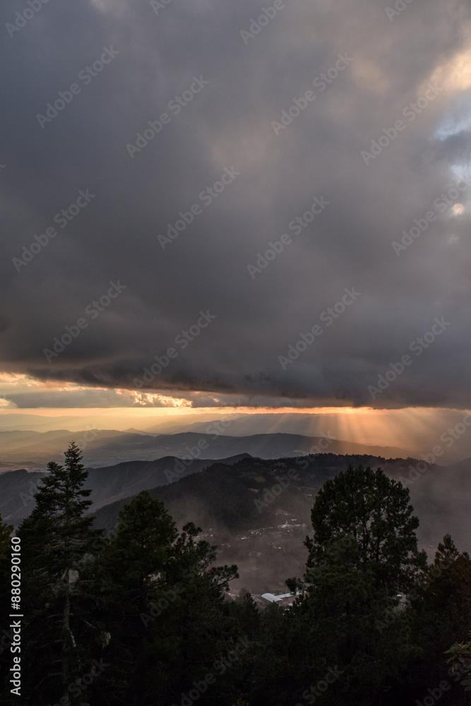 View from the mountains with cloudy skies in the forest during sunset View from the mountains with cloudy skies in the forest during sunset