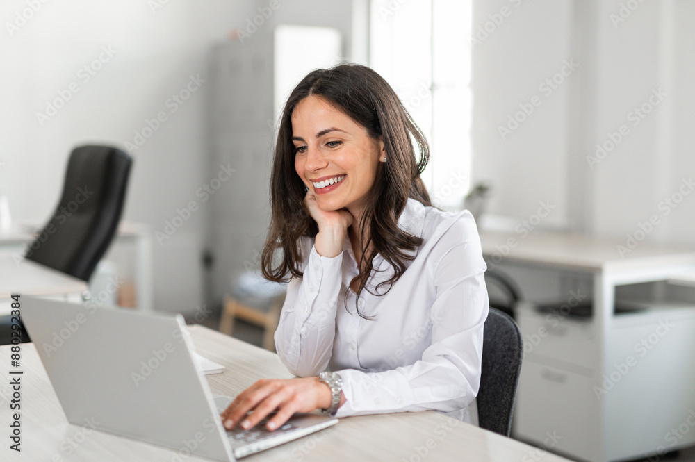 Young brunette smilling and working in her office Young brunette smilling and working in her office