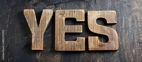 Close up of the word YES displayed on wooden letter signs against a black board backdrop with copy space image. photo