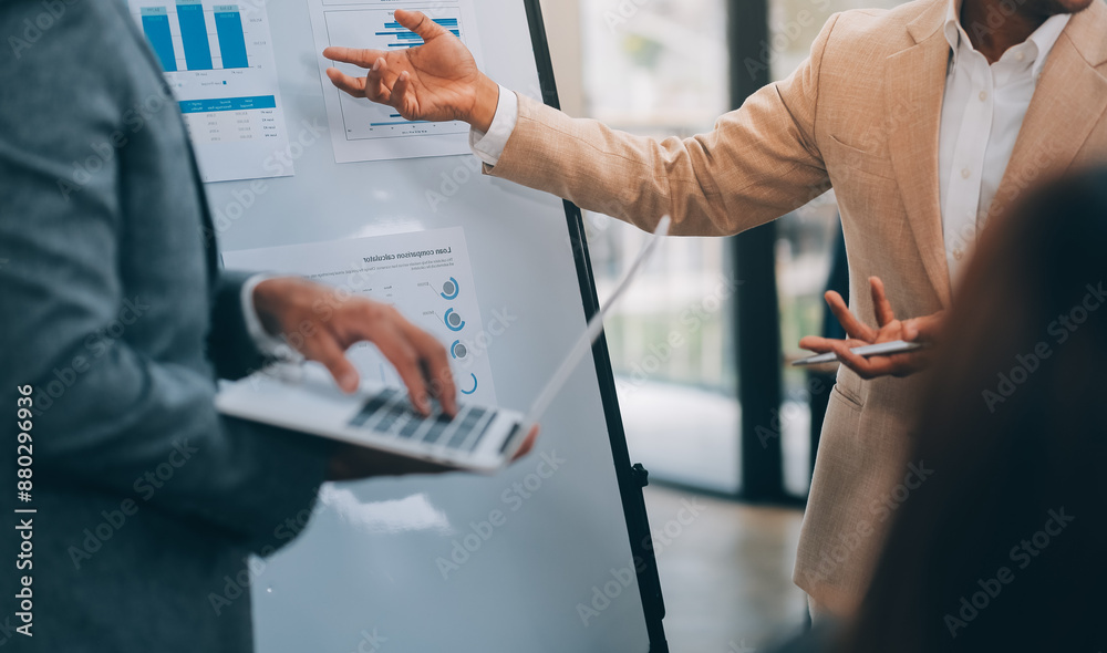 Obraz premium Young Businesspeople Working with Laptop in Modern Office. Office Workers at Work. Communication and Discussion at Work Concepts. Business Concept. Businessman and Businesswoman Concepts.