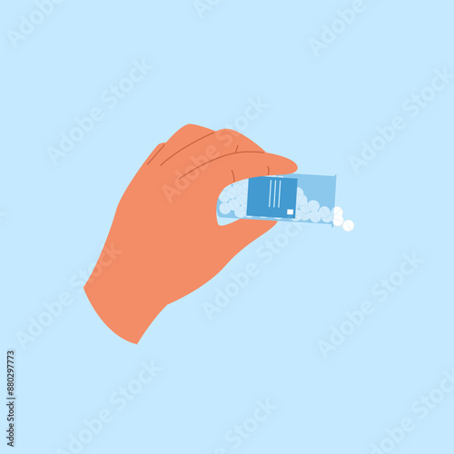Hand holds bottle with pills spilling out. Open container with antibiotic tablets