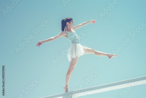 Elegant Ballerina Performing Balancing Act on a White Beam Against Clear Sky © Anna