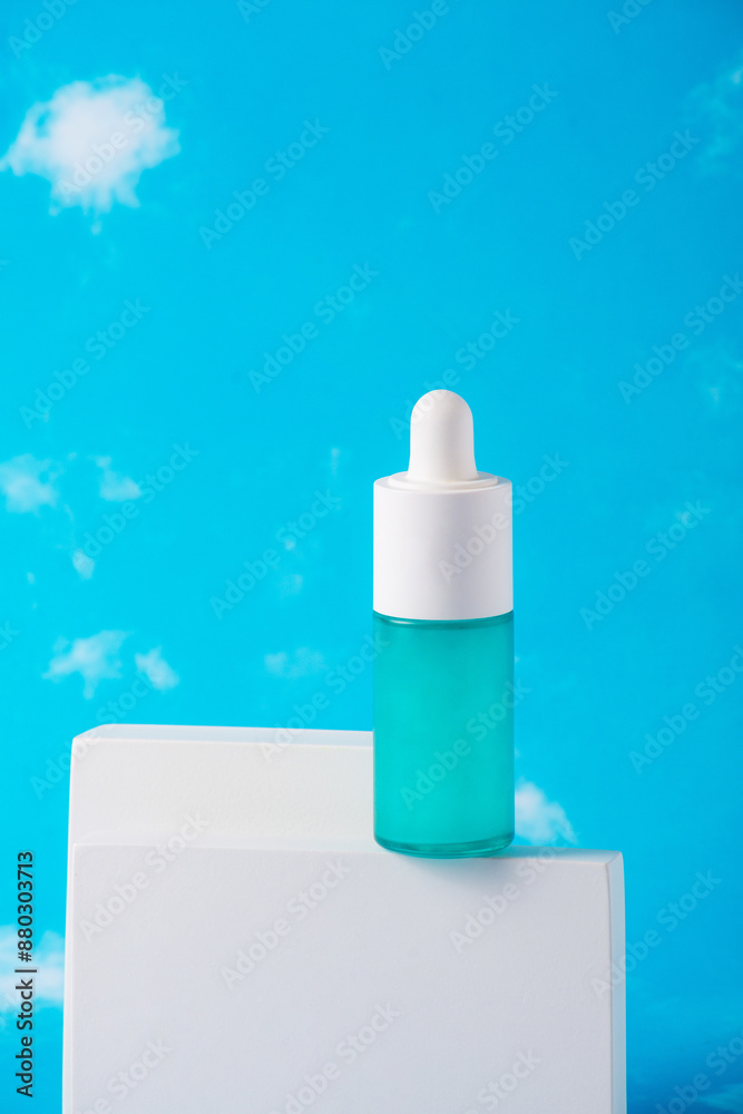 Blue glass cosmetic bottle, Skin care or sunscreen cosmetic with stylish props on sky background. Blue glass cosmetic bottle, Skin care or sunscreen cosmetic with stylish props on sky background.