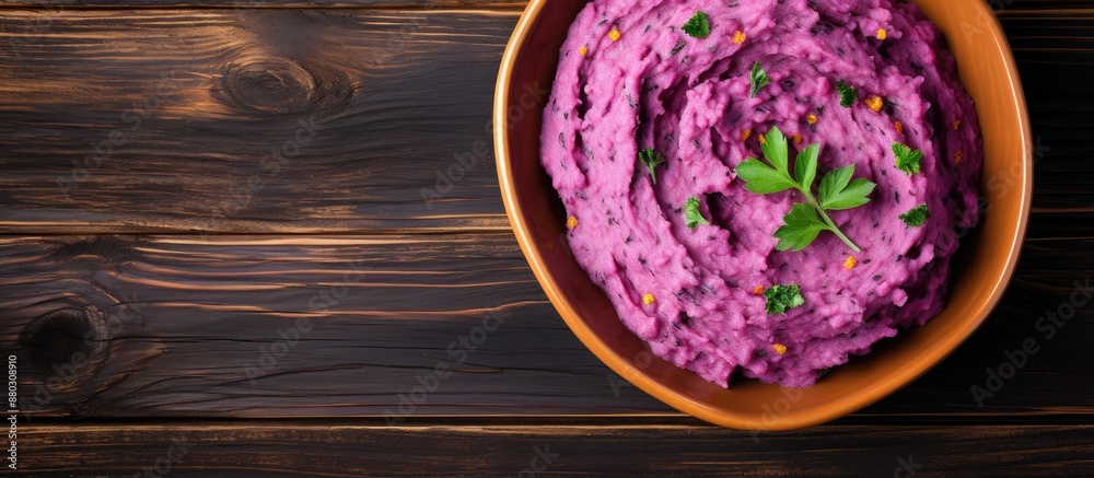 Top view of a dish with purple sweet potatoes and mashed potatoes on a wooden table, ideal for text placement in a vegan and healthy fruit concept with copy space image. Top view of a dish with purple sweet potatoes and mashed potatoes on a wooden table, ideal for text placement in a vegan and healthy fruit concept with copy space image.