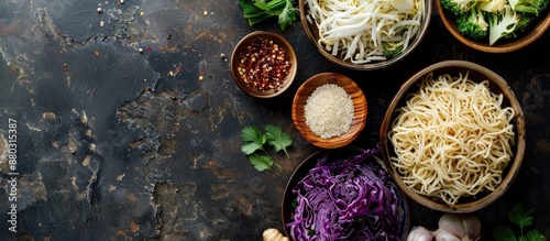 Asian meal ingredients like noodles, rice, cabbage, ginger, and onion for a nutritious meal preparation, viewed from above with room for text in the image.
