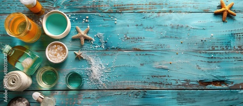 Various samples of shampoo, shower gel, perfume, and bath salts arranged on a rustic blue wooden table with a weathered appearance, providing space for a graphical element. photo