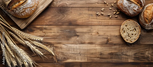 Wheat and bread are beautifully arranged on a vintage wooden surface with an open area to add text or other elements in the photograph (copy space image). photo