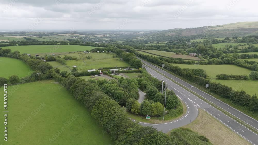 Aerial view of the A30 in rural Devonshire countryside UK, featuring fields, greenery, and traffic Aerial view of the A30 in rural Devonshire countryside UK, featuring fields, greenery, and traffic