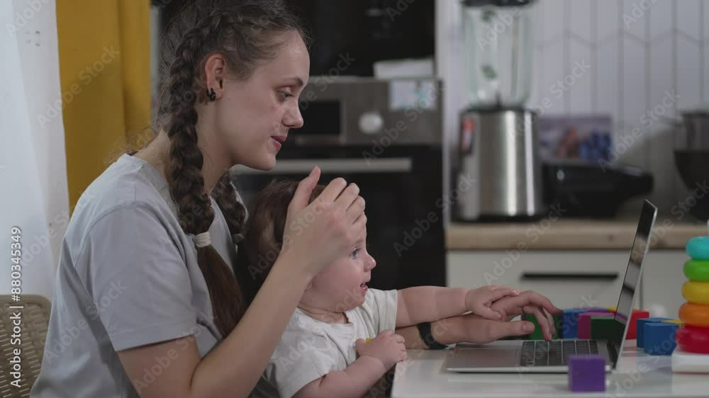 Happy home work with mom and baby. Cheerful work from home mother with joyful child. Happy baby helps mom at laptop. Work and play blend at home. Mother and baby happy working at home with laptop. Happy home work with mom and baby. Cheerful work from home mother with joyful child. Happy baby helps mom at laptop. Work and play blend at home. Mother and baby happy working at home with laptop.
