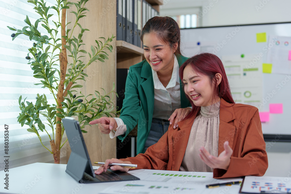 Obraz premium Analysis. Discussion. Asian female economist and marketer pointing at financial data sheet to plan company's financial growth. Negotiation. Expressing ideas. Successful teamwork concept.
