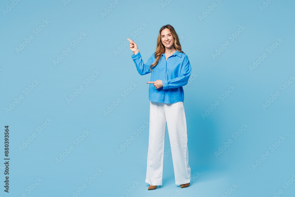 Full body young woman she wear shirt casual clothes point index finger aside indicate on workspace area copy space mock up isolated on plain pastel light blue cyan background studio Lifestyle concept