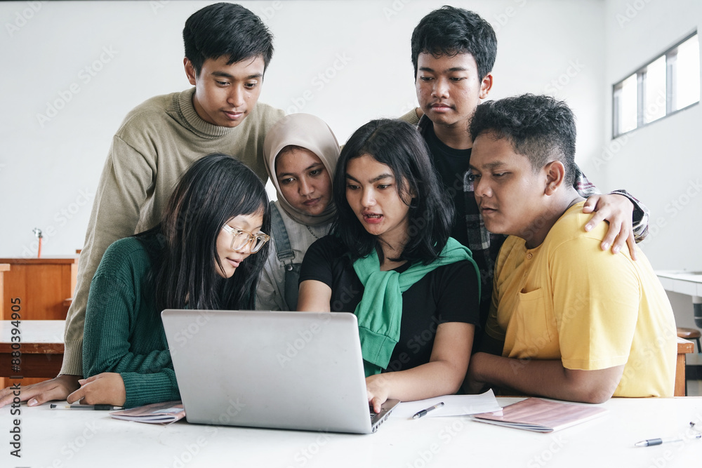 Group of Asian Multiethnic College Students Watching Laptop In Classroom Group of Asian Multiethnic College Students Watching Laptop In Classroom