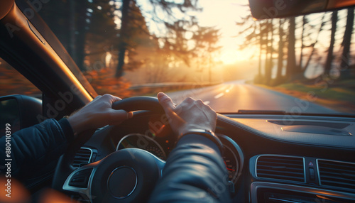 A man in love driving a car along a road along a forest during sunset.