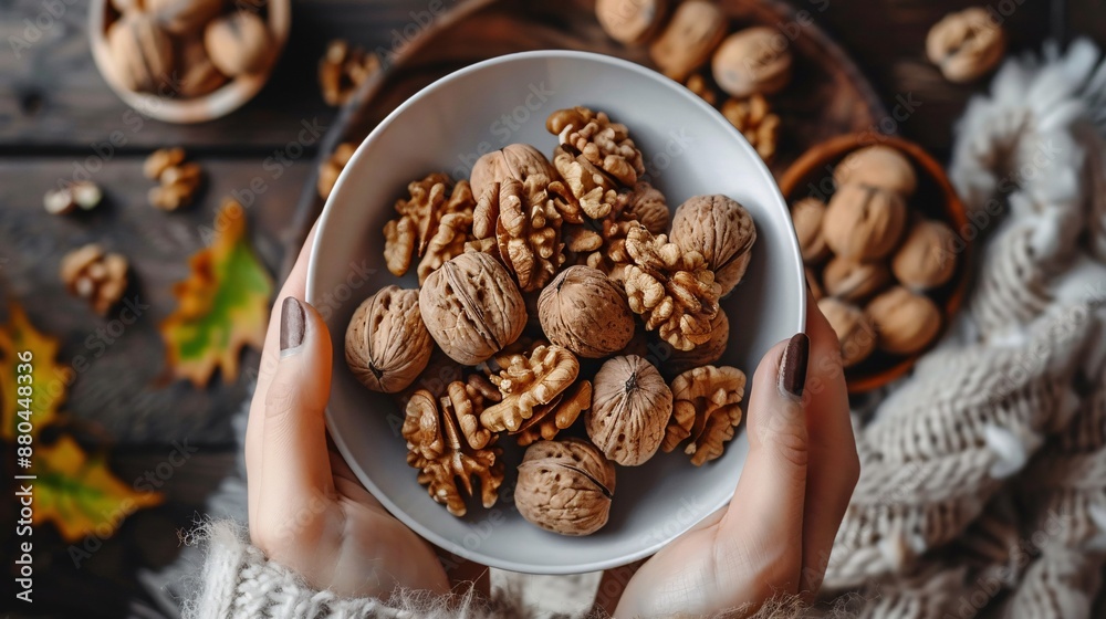 Handful of unshelled walnuts held by woman on wooden background, promoting healthy eating and nutrients. Handful of unshelled walnuts held by woman on wooden background, promoting healthy eating and nutrients.