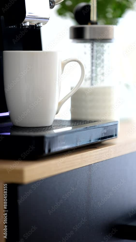 coffee machine pours frothed milk, beautiful blurred background with a bouquet of flowers, sunny day, morning home routine coffee machine pours frothed milk, beautiful blurred background with a bouquet of flowers, sunny day, morning home routine