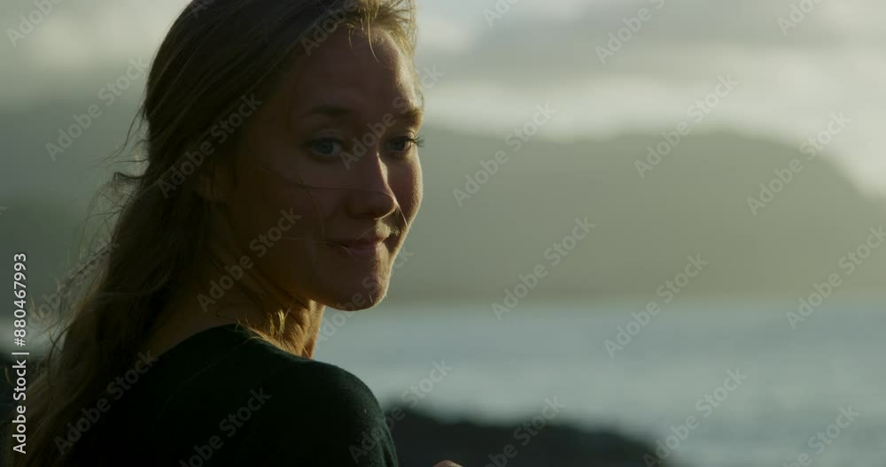 Silhouette of smiling woman near beach at sunset - close up