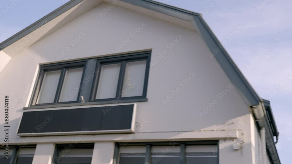 holland modern house swith a sloped roof against a clear blue sky, showcasing architectural details and a serene suburban setting holland modern house swith a sloped roof against a clear blue sky, showcasing architectural details and a serene suburban setting