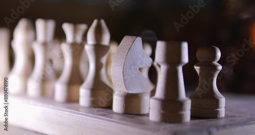 A detailed closeup view showcases wooden chess pieces strategically arranged on a board photo