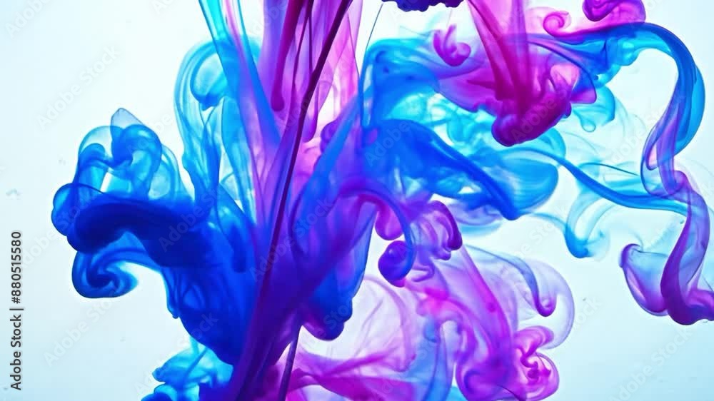 Close up of blue and pink ink being poured into water, where it melts into mystical patterns. Close up of blue and pink ink being poured into water, where it melts into mystical patterns.