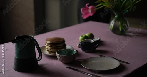 Tasty pancake breakfast with jam and apple. Tea served on a kitchen table. Simple life or perfect morning concept