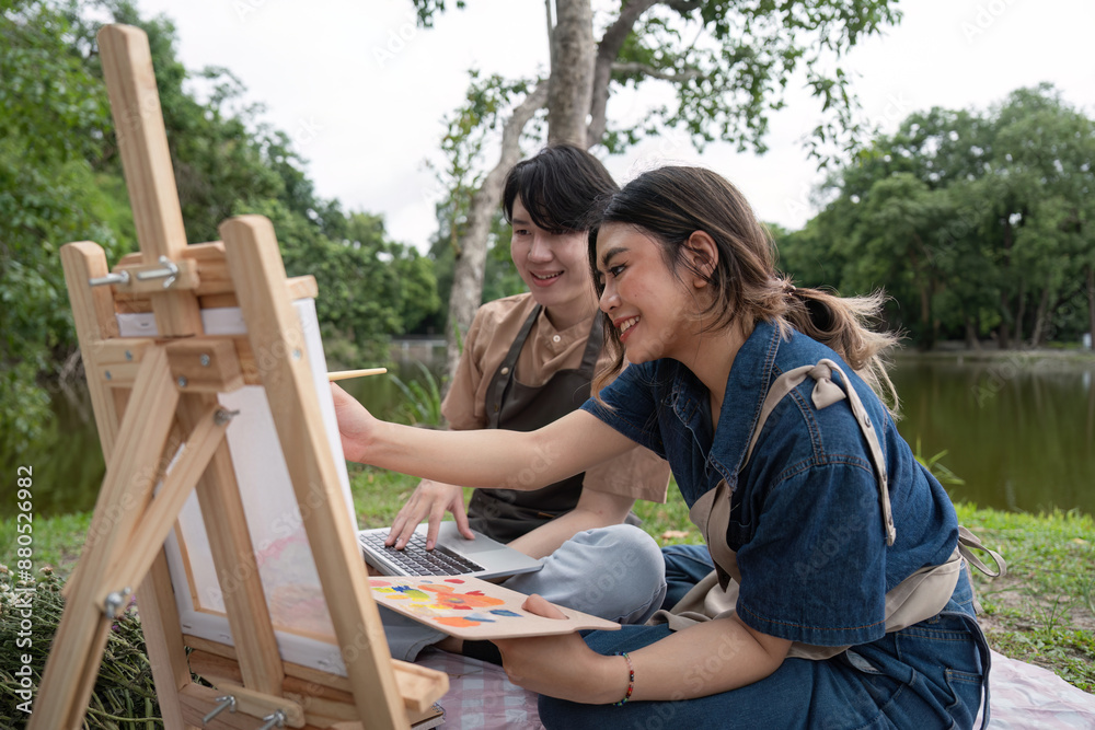 Fototapeta premium Romantic Couple Enjoying a Picnic While Drawing and Painting Outdoors in a Serene Park Setting