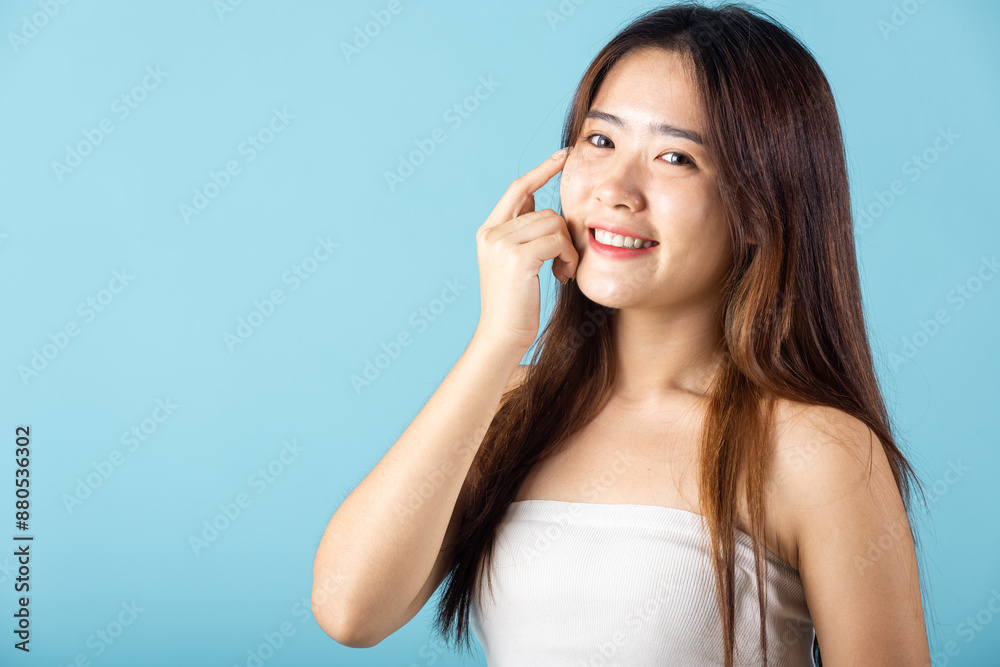 Beauty and Skin care. Beautiful woman model smiling with natural makeup and healthy face, Asian female with beauty face touching healthy facial skin studio shot isolated on blue background Beauty and Skin care. Beautiful woman model smiling with natural makeup and healthy face, Asian female with beauty face touching healthy facial skin studio shot isolated on blue background