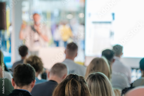 Participants attentively listening to a presenter at a business seminar or conference. The image captures a focused audience in a professional learning environment.