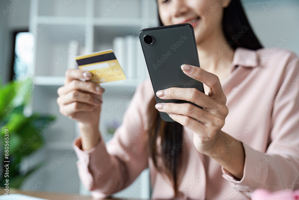 Woman Using Credit Card for Online Shopping on Smartphone in Modern Home Office Setting Woman Using Credit Card for Online Shopping on Smartphone in Modern Home Office Setting
