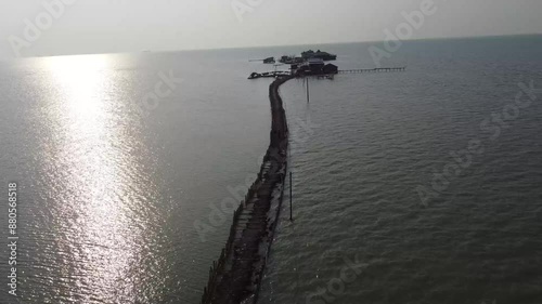 Aerial view of wooden pier extending into the sea at sunset photo