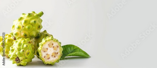 Noni fruit displayed against a plain white backdrop with space for copy photo
