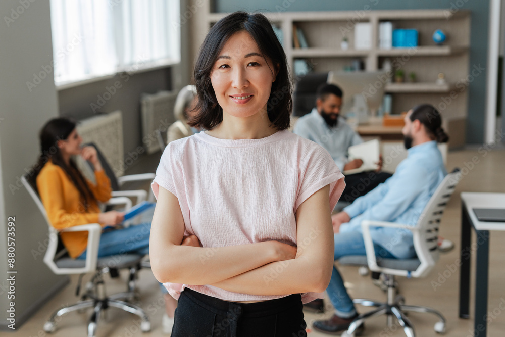 Confident asian businesswoman smiling with arms crossed in modern office Confident asian businesswoman smiling with arms crossed in modern office