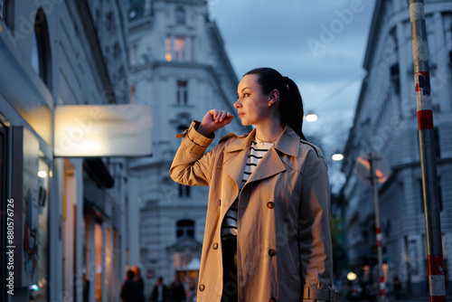 Photography Portrait of beautiful caucasian woman wearing coat is walking by night Wien street