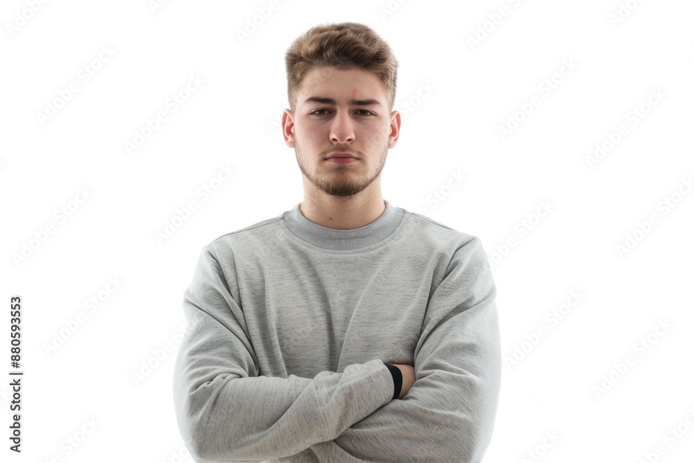 A person with their arms crossed standing in front of a white background A person with their arms crossed standing in front of a white background