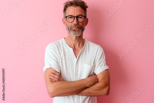 Middle age confident Caucasian man isolated on pink background with arms crossed