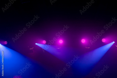 An empty stage, lit by spotlights and smoke before the performance