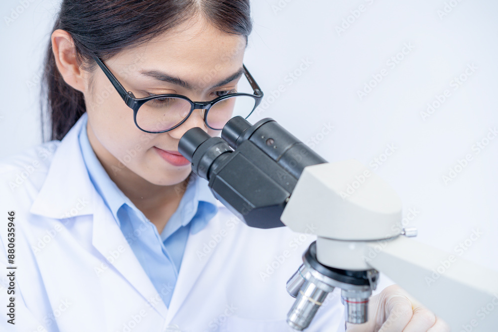 A female scientist is working with a microscope A female scientist is working with a microscope