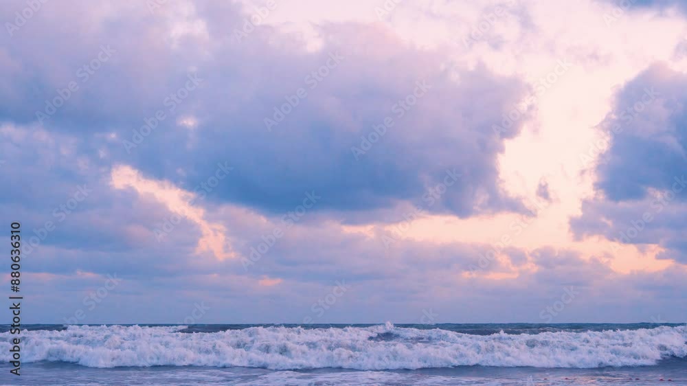 Waves Falling on the Ocean Shore at Sunrise Lilac Blue Yellow Sky and Rain Cumulus Clouds. Colorful Dawn Sky with Storm Clouds and Foaming Waves Rolling on the Sea Shore, Background, Planet. Waves Falling on the Ocean Shore at Sunrise Lilac Blue Yellow Sky and Rain Cumulus Clouds. Colorful Dawn Sky with Storm Clouds and Foaming Waves Rolling on the Sea Shore, Background, Planet.
