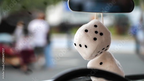 Canvas Print White fuzzy dice hanging from rearview mirror in a car