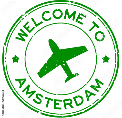 Grunge green welcome to amsterdam with airplane icon round rubber seal stamp on white background