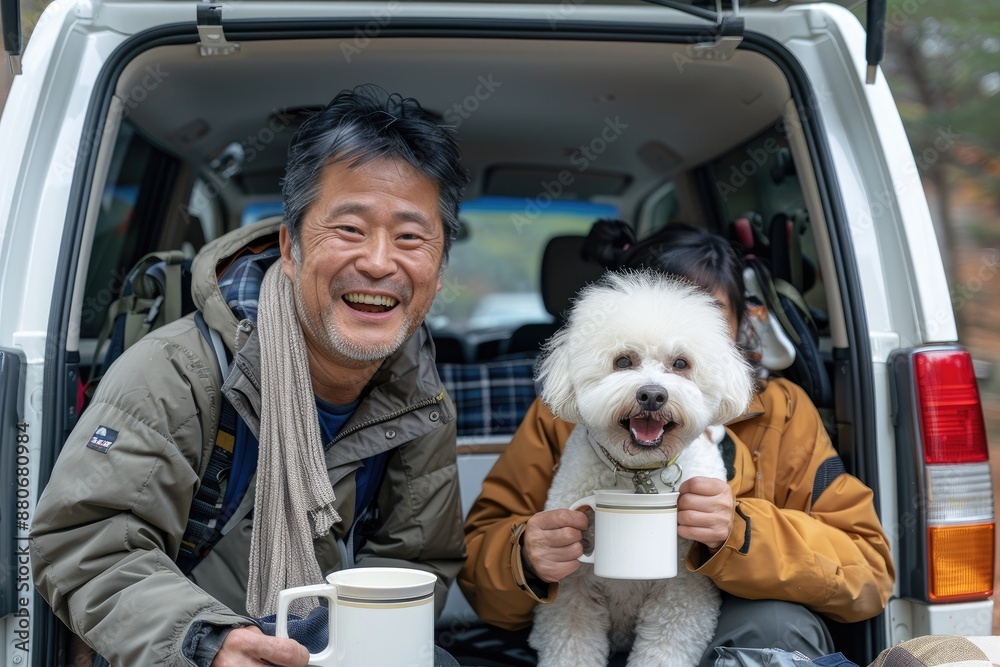 A Japanese couple and a white bichon dog, sitting in the back of an SUV with the doors on both sides open, are smiling at the camera while holding coffee mugs. A Japanese couple and a white bichon dog, sitting in the back of an SUV with the doors on both sides open, are smiling at the camera while holding coffee mugs.