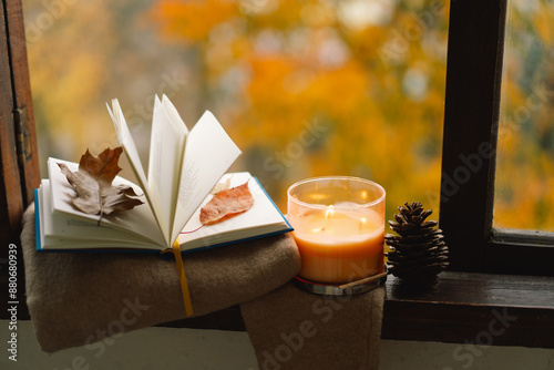 Sweet Home. Still life details in home on a wooden window. Sweater, candle and autumn decor. Autumn home decor. Cozy fall mood. Cozy autumn or winter concept.